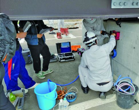 KGSの営業社員が非破壊検査機器を使用して現場調査を行う様子